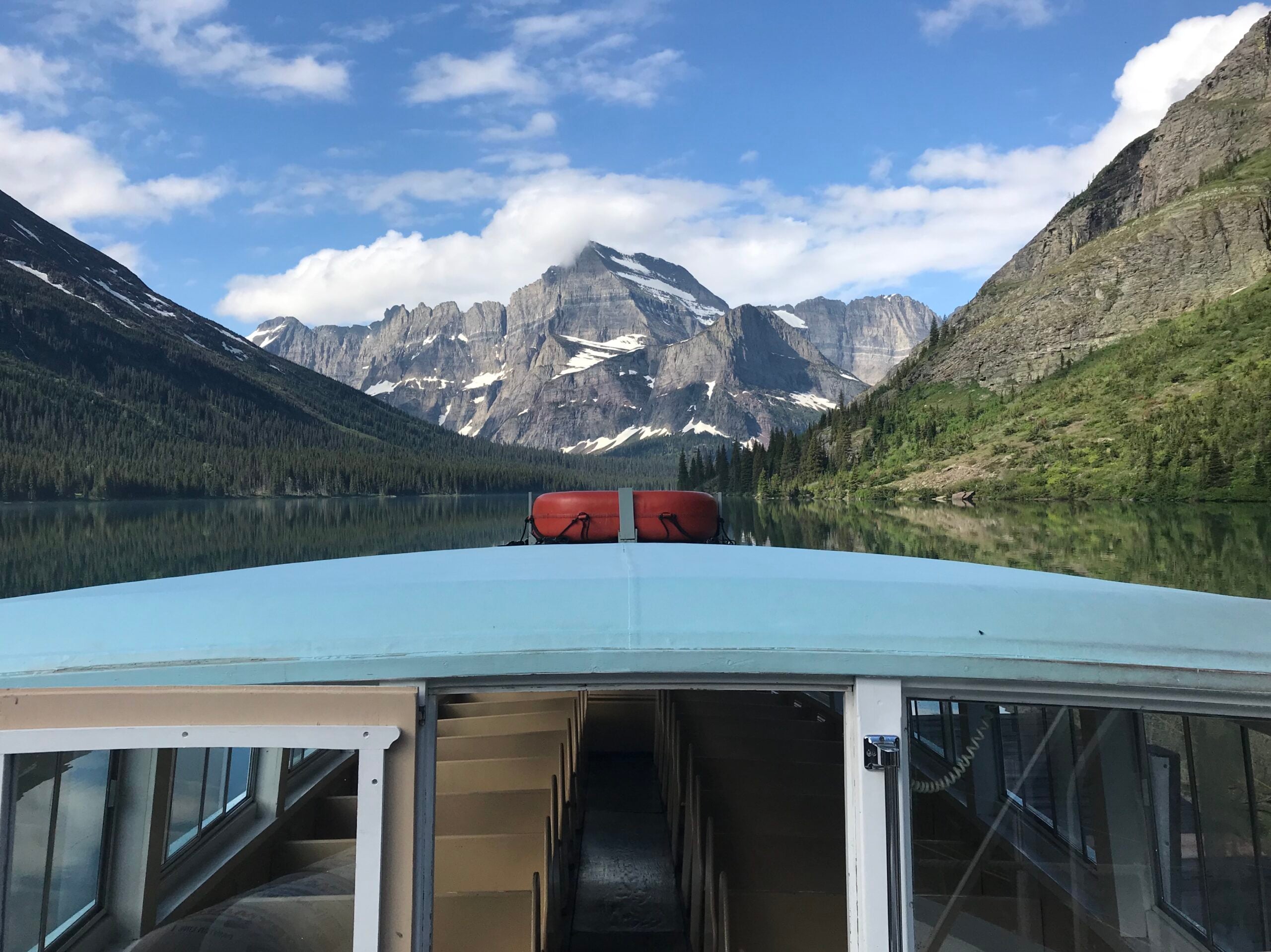 boat on lake with mountain peak behind