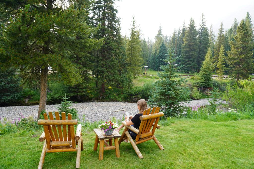 woman sitting on log chairs by river