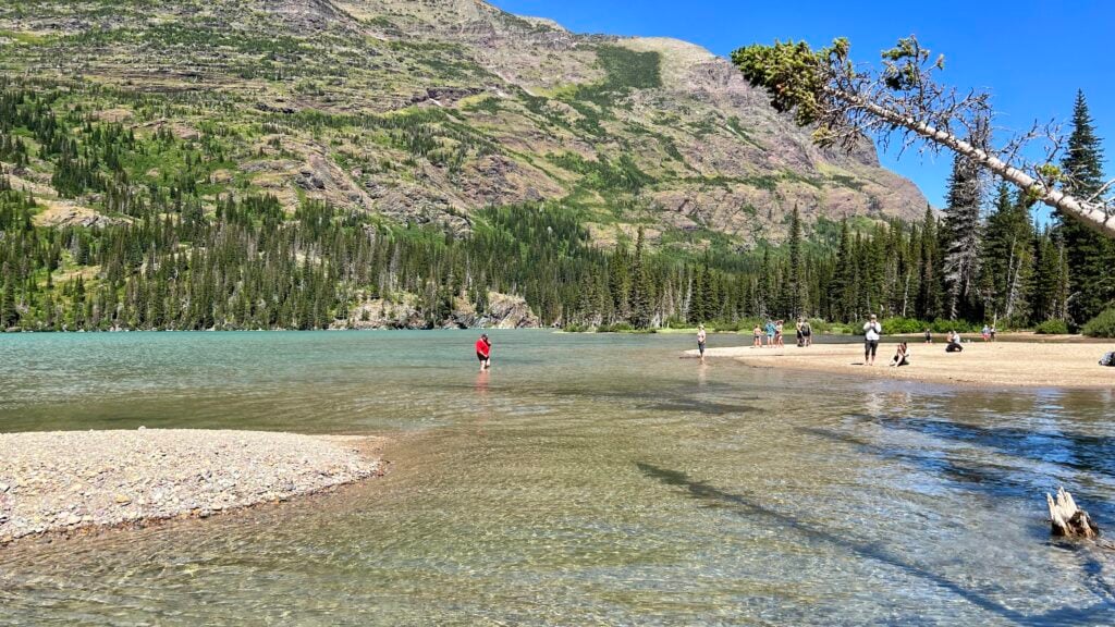 people wading in the shallows of a lake