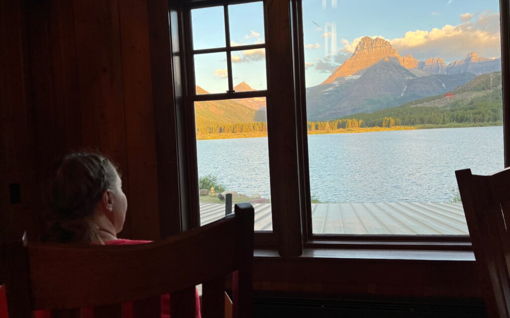 woman looking at view out window in ptarmigan dining room Glacier