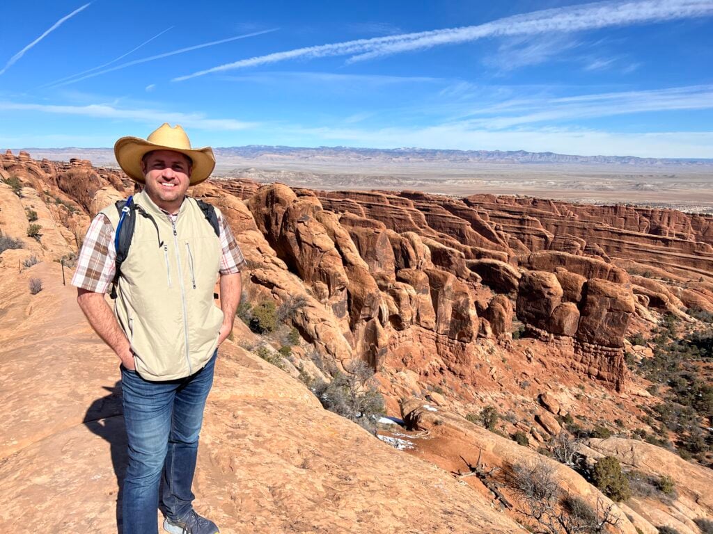 man at in front of rock formations in Arches National Park