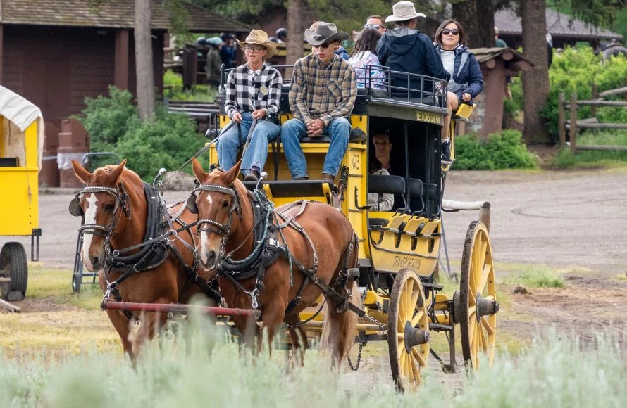 people riding in yellow stagecoach