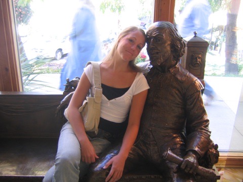 Woman sitting next to a statue of Shakespeare