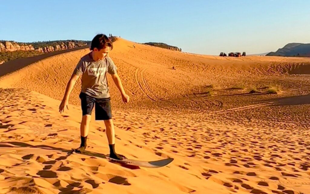 child sand boarding at coral pink sand dunes state park