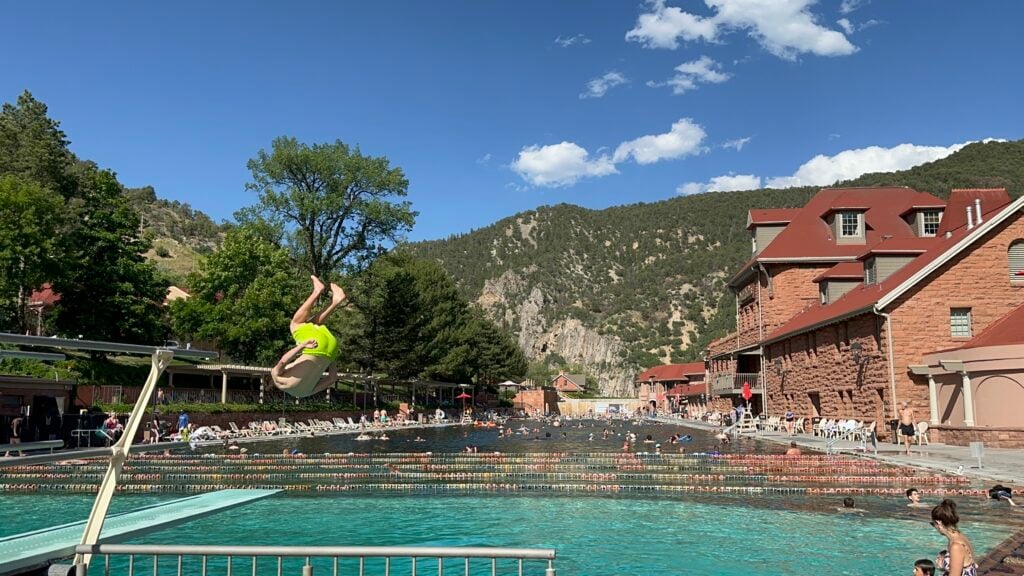 people swimming and jumping into pool