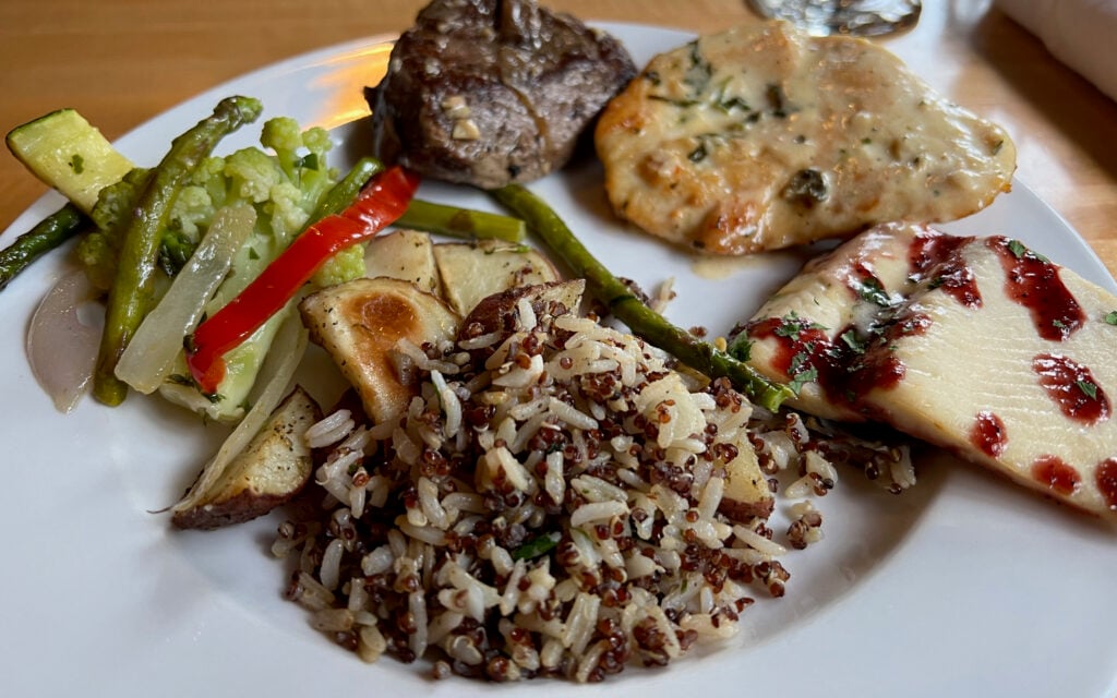 plate of chicken, fish, rice, steak veggies at restaurant