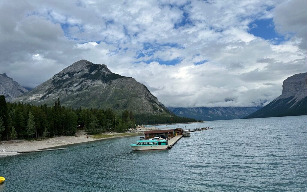 View of boat dock at Lake Minnewanka with clouds in background