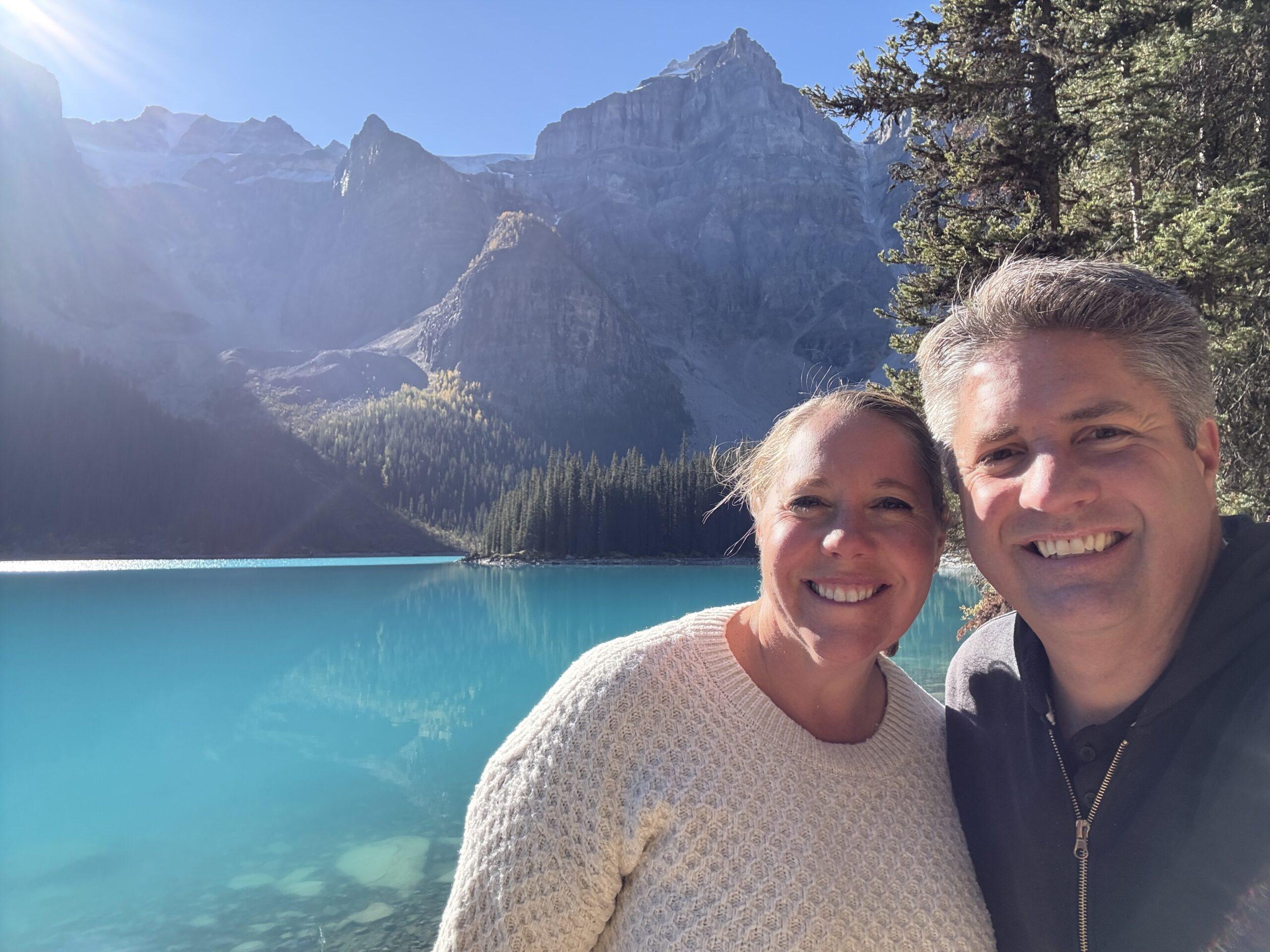 man and woman in front of glacial lake