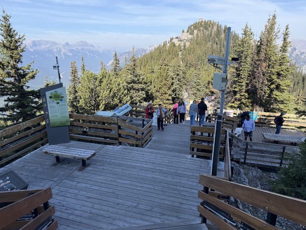 people walking on boardwalk on top of mountain