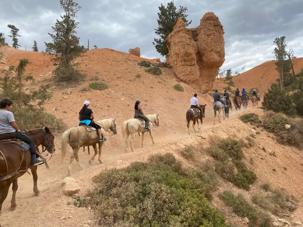 people riding horses along trail in Bryce Canyon