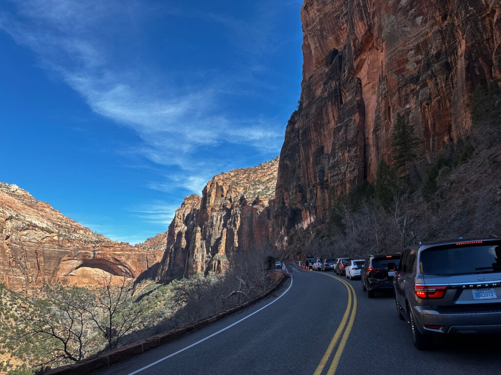 cars lined up on road to go through tunnel