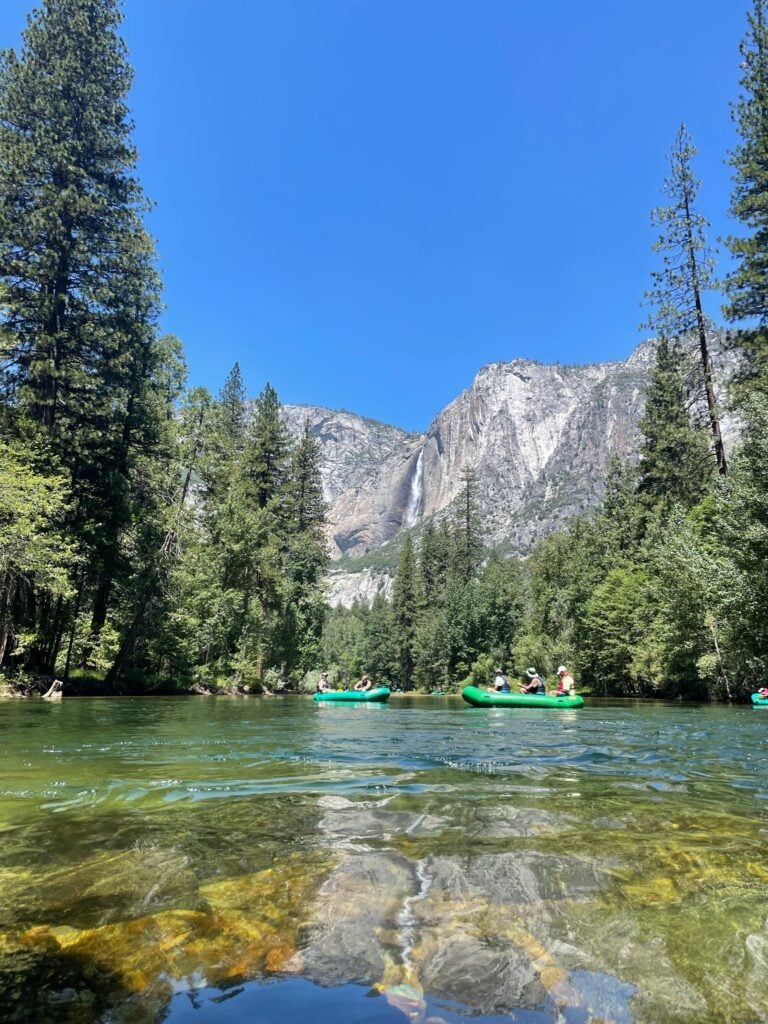 people floating in rafts on river