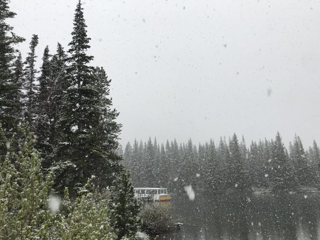 snow falling on boat on lake