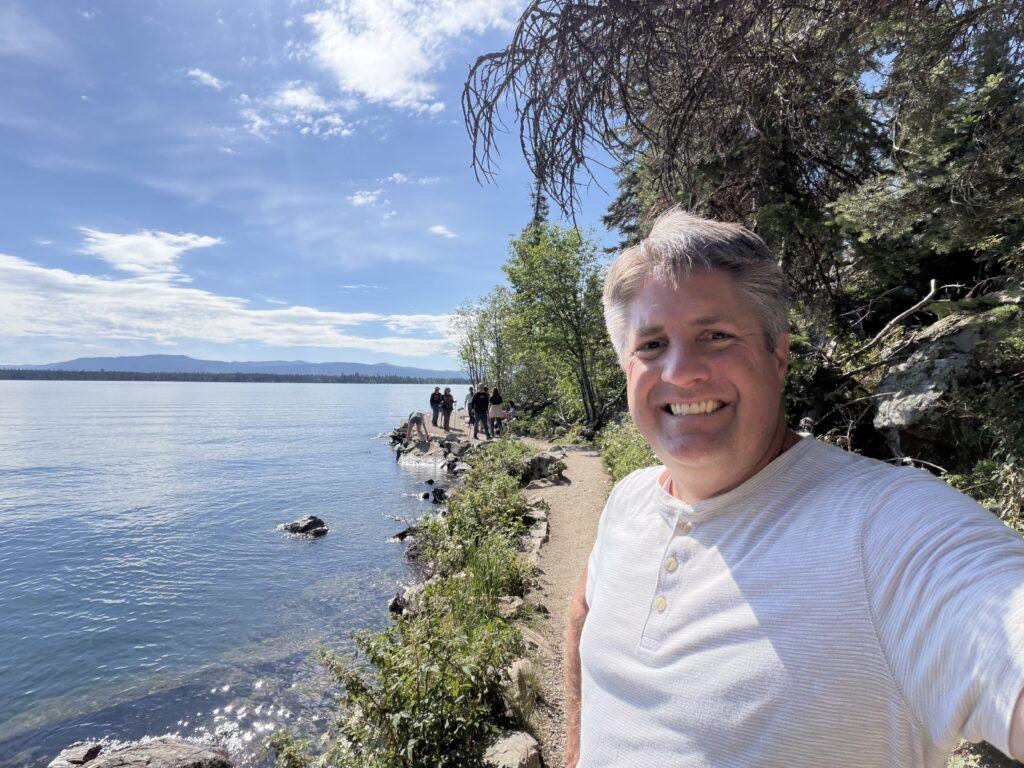 man standing next to lake