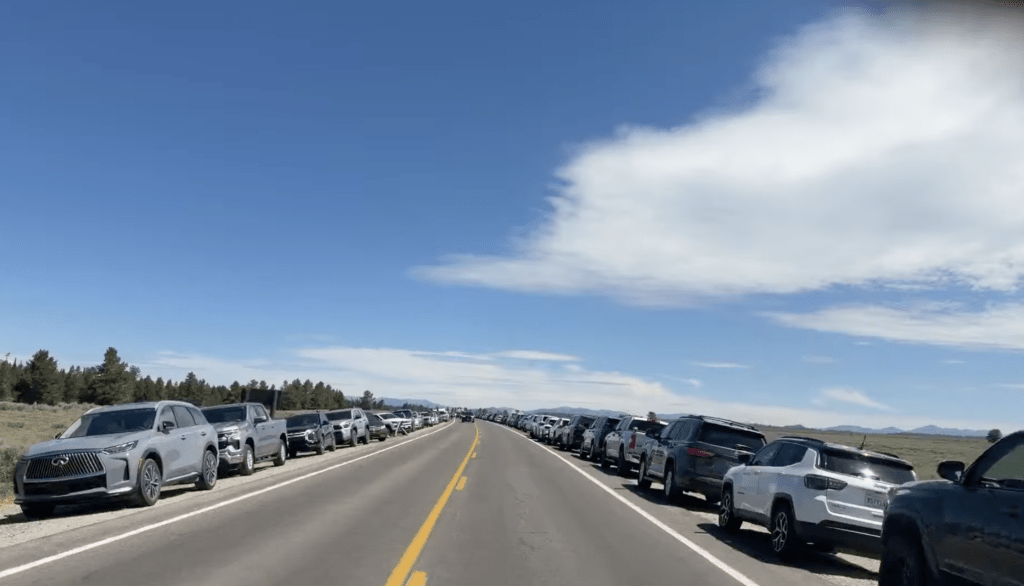 road with cars parked on the side in Grand Teton