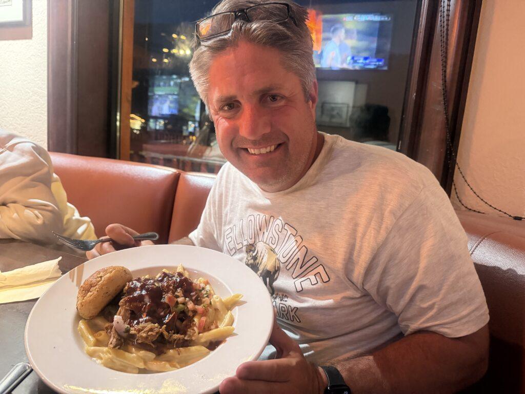 man with dish of pasta with meat