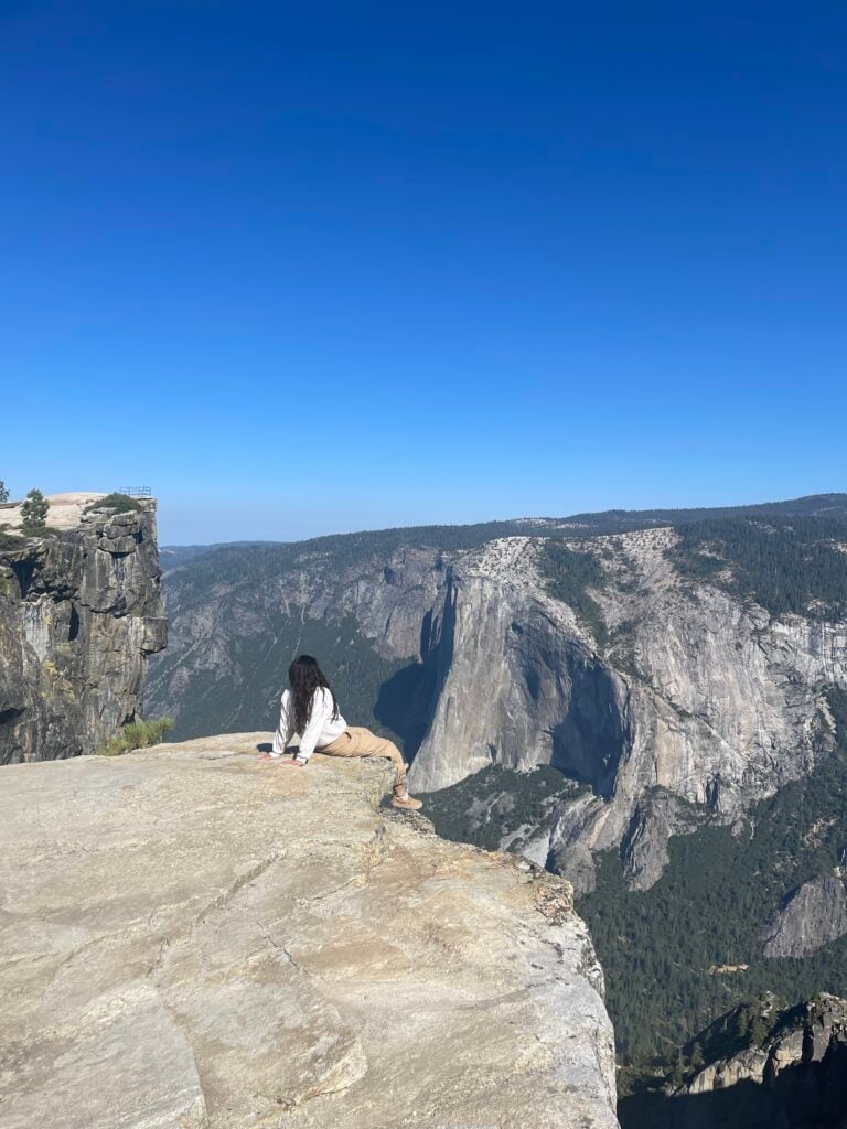 girl sitting on edge of cliff