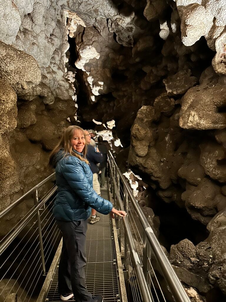 Woman standing on metal walkway inside of a cave