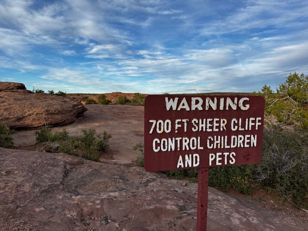 Sign in front of a cliff warning people not to get too close
