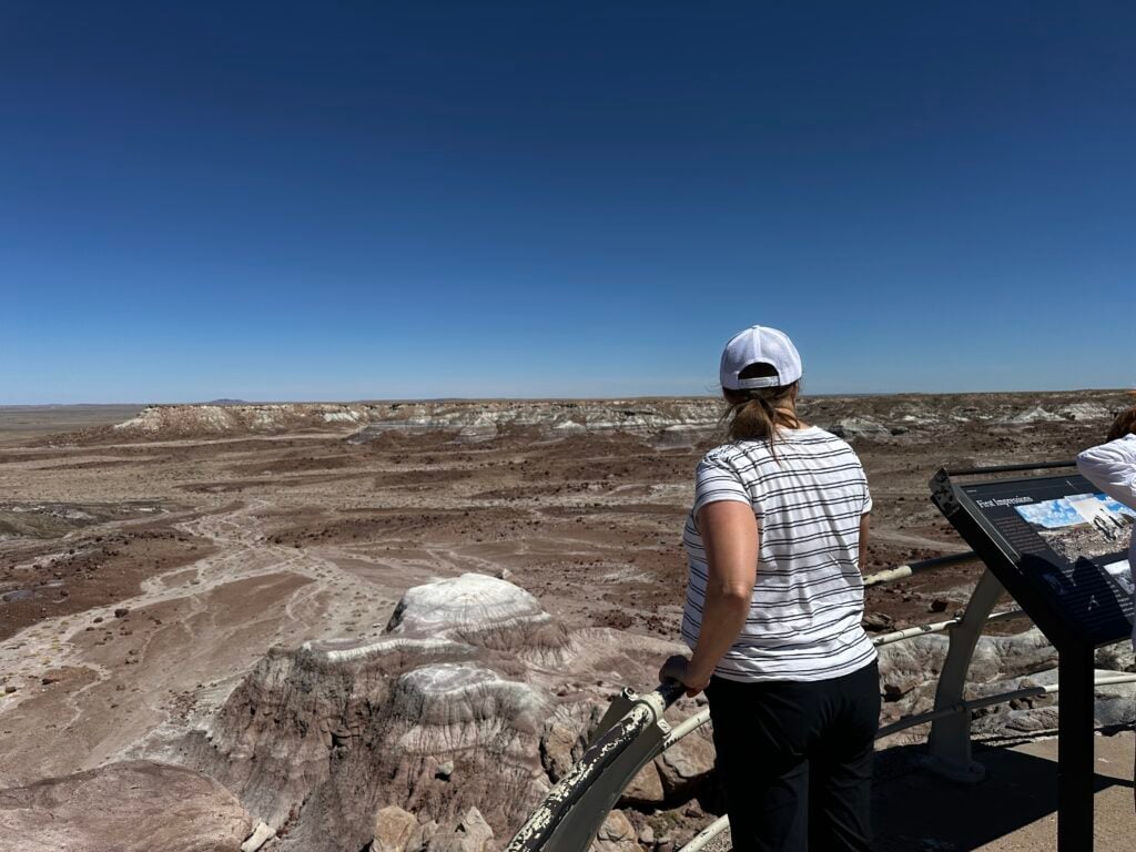 Woman at an overlook looking at white capped sand hills