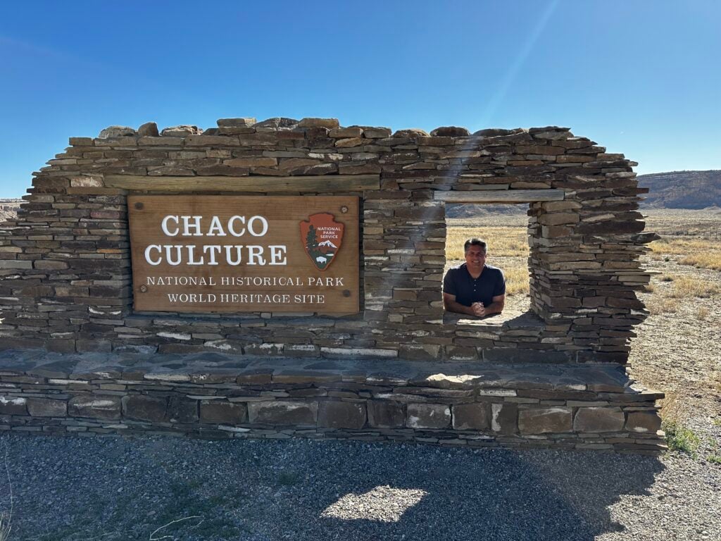 Man peering out of window of Chaco Culture sign