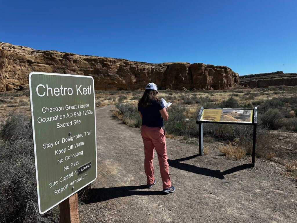 Woman standing on trail looking at map in the desert