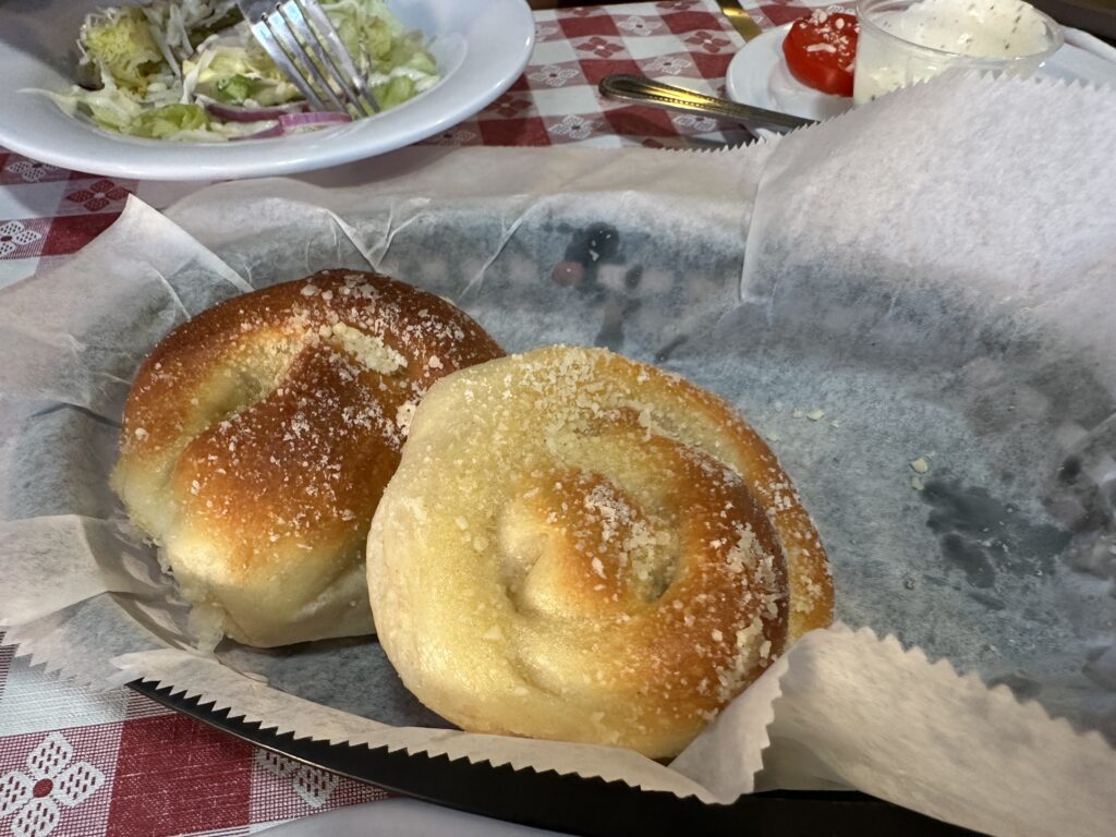 Two rolls covered in parmesan cheese