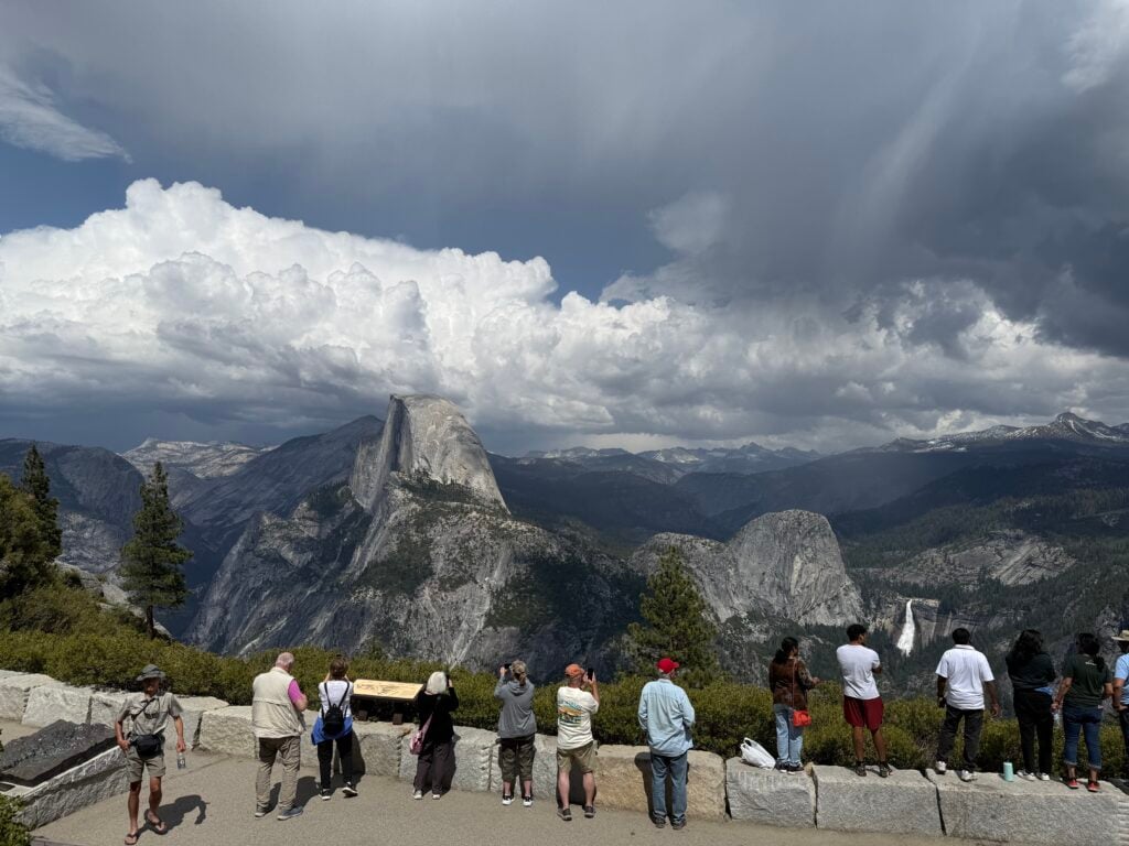 people looking at valley, mountains, and waterfall in Yosemite