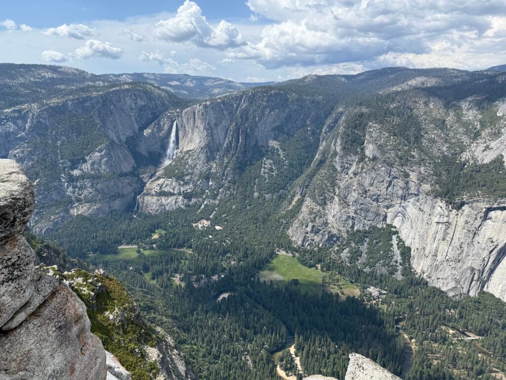view of mountains, valley, and waterfall