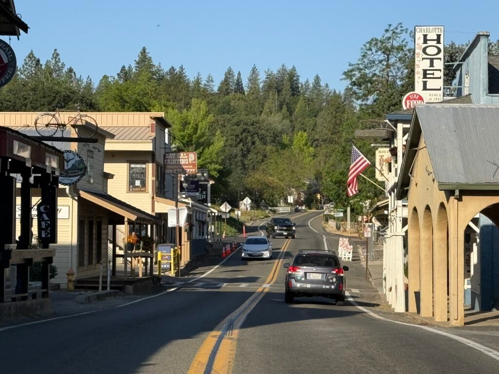 cars driving on road through small town