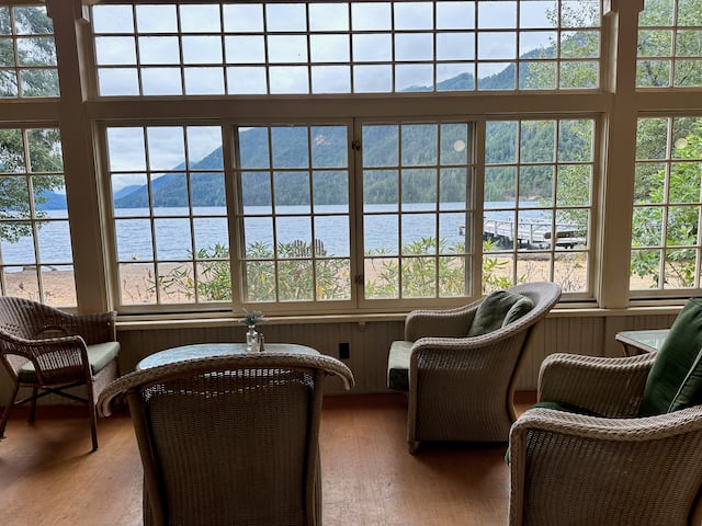 lounge chairs and table next to large window with a view