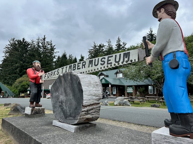 statue of two men sawing a large log
