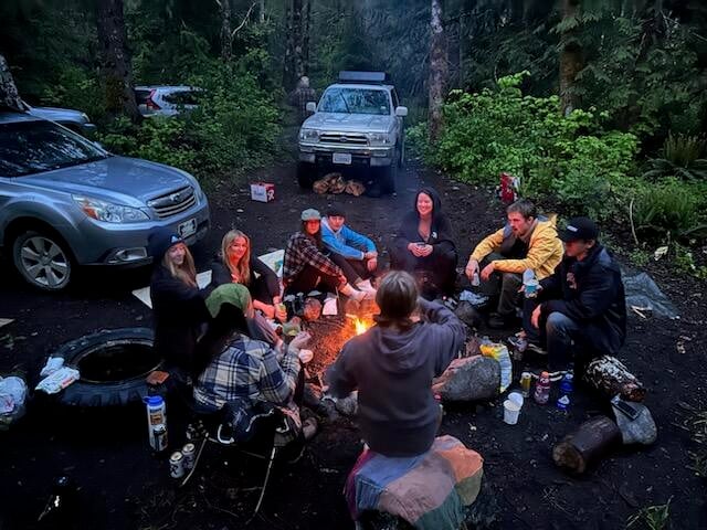 people sitting around a campfire