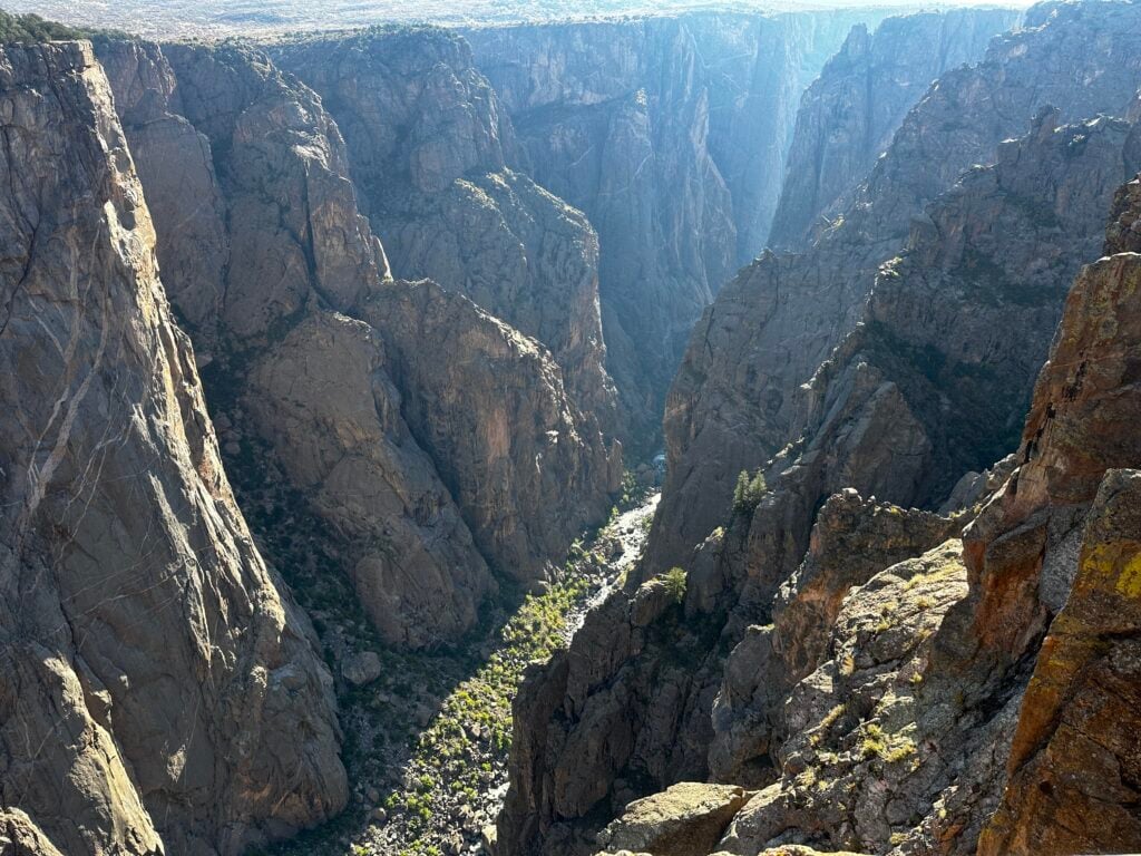 canyon with a river at the bottom and black walls