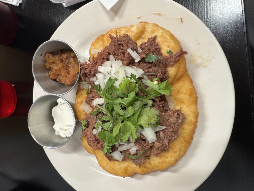Indian Taco on plate with salsa and sour cream on the side