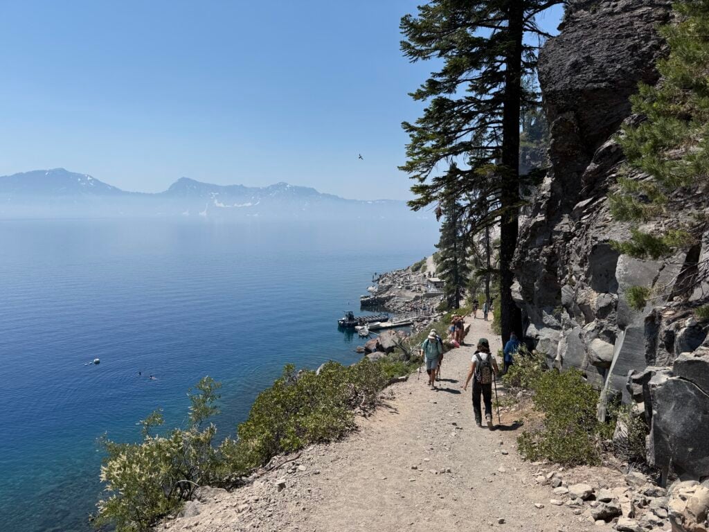 Packed dirt trail with a lake and mountains in view