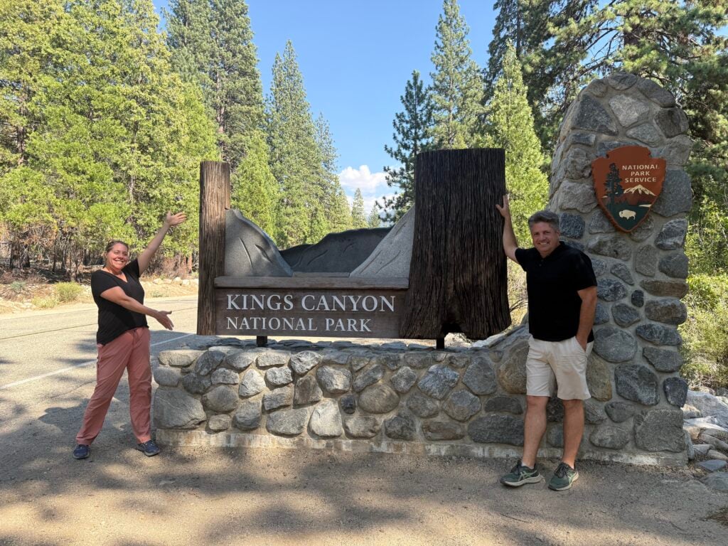 Man and woman standing at the Kings Canyon Entrance Sign
