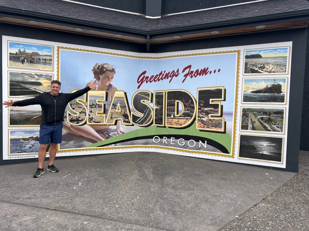 man in front of Seaside, Oregon sign
