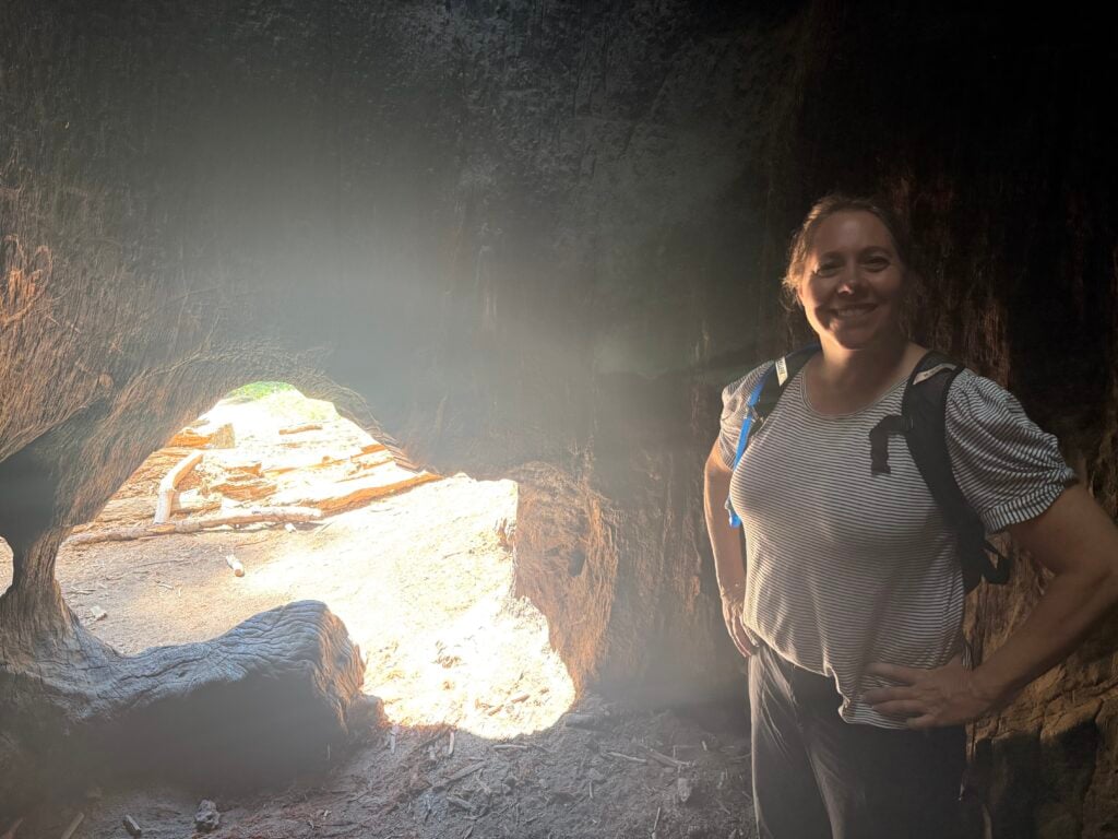 Woman standing inside a hollowed out tree