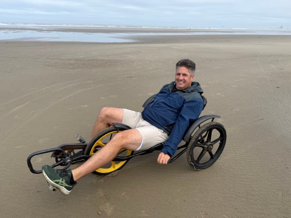 man riding recumbent bicycle on beach