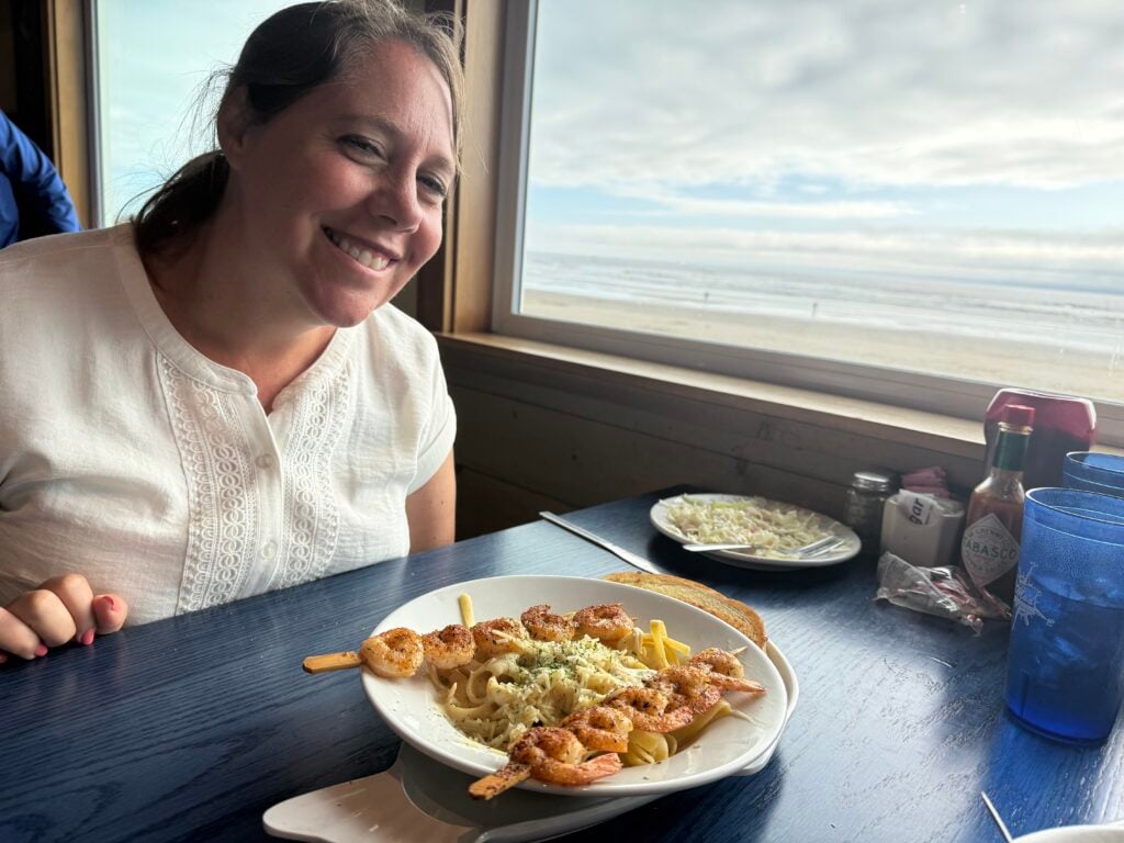 woman at table with shrimp alfredo on plate