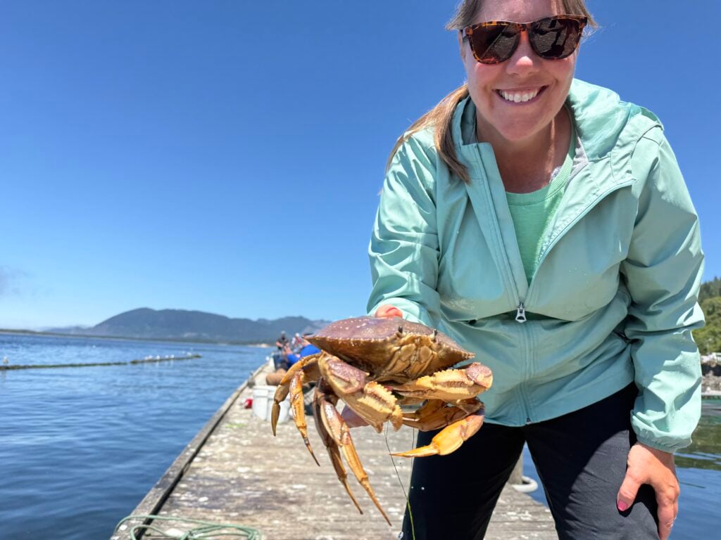 woman holding crab on dock