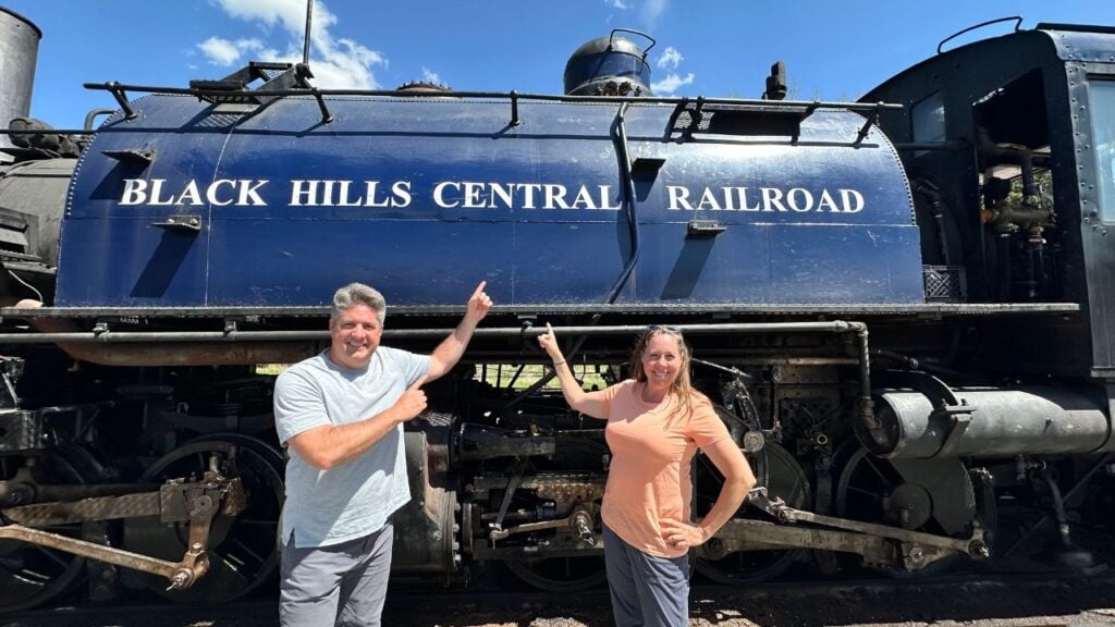 man and woman standing in front of train engine