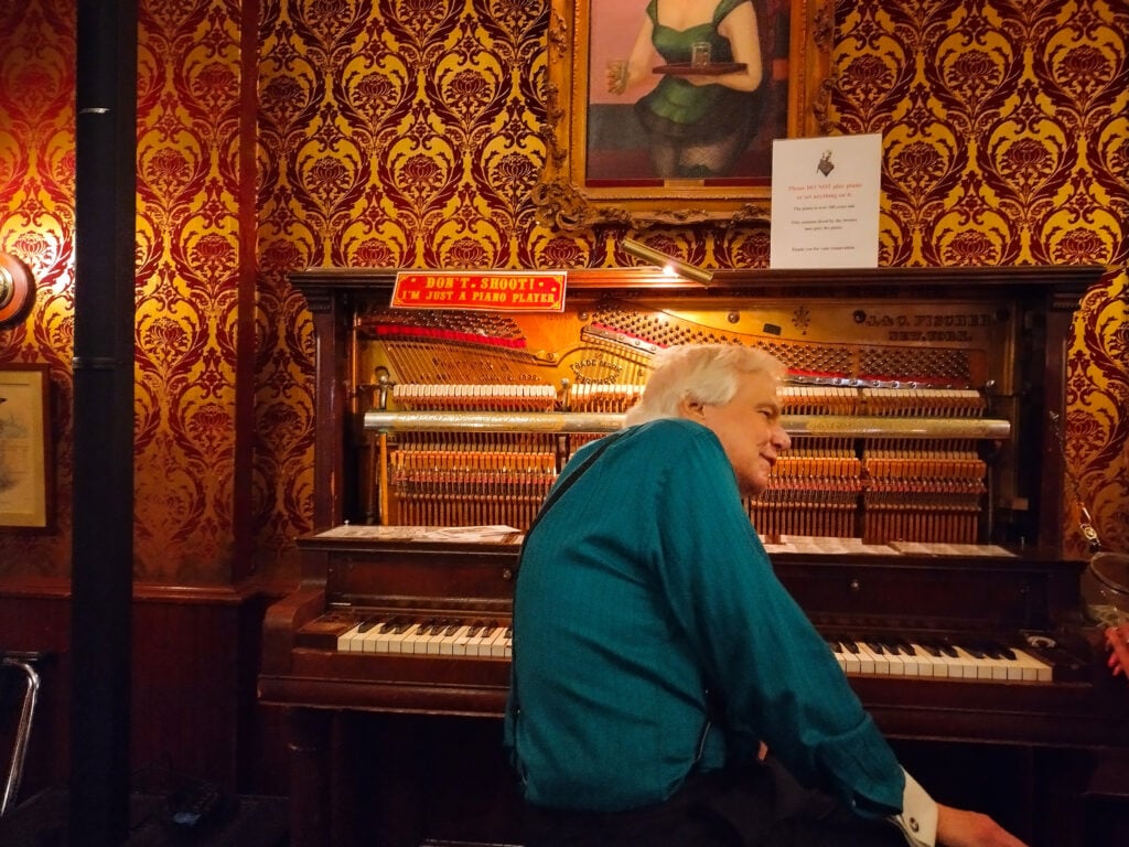 man sitting at old piano