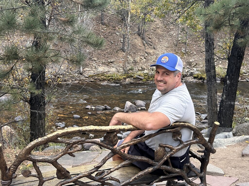man sitting on bench near river