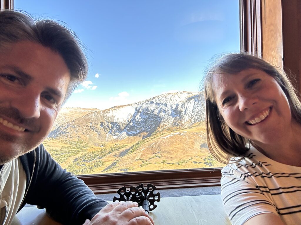 man and woman selfie with view from cafe in RMNP