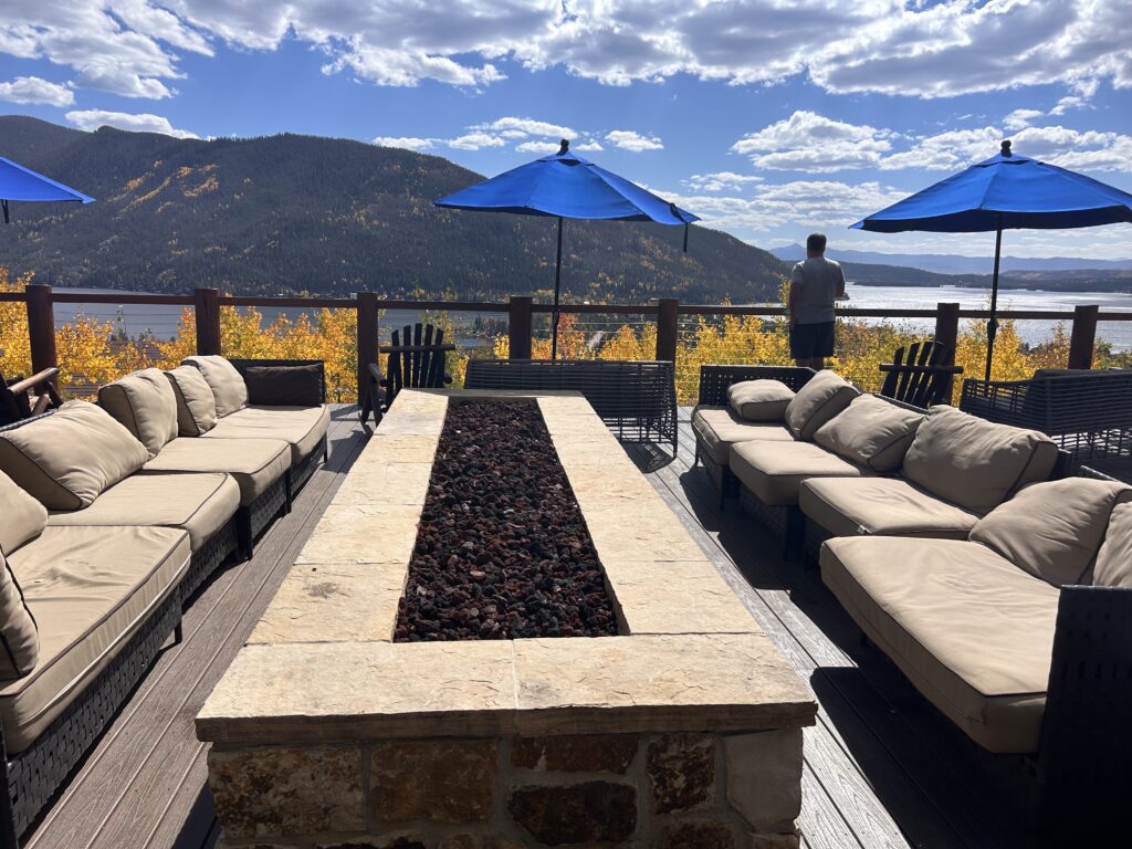 deck with firepit and couches with view of lake