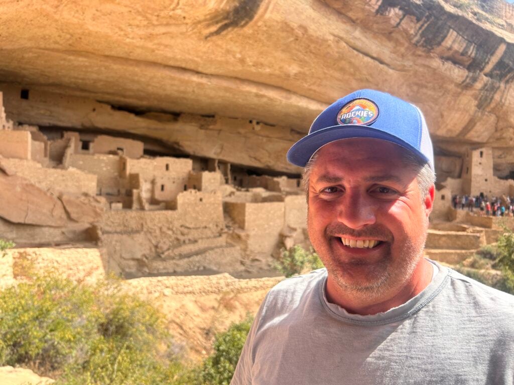 man in front of cliff dwelling in Mesa Verde
