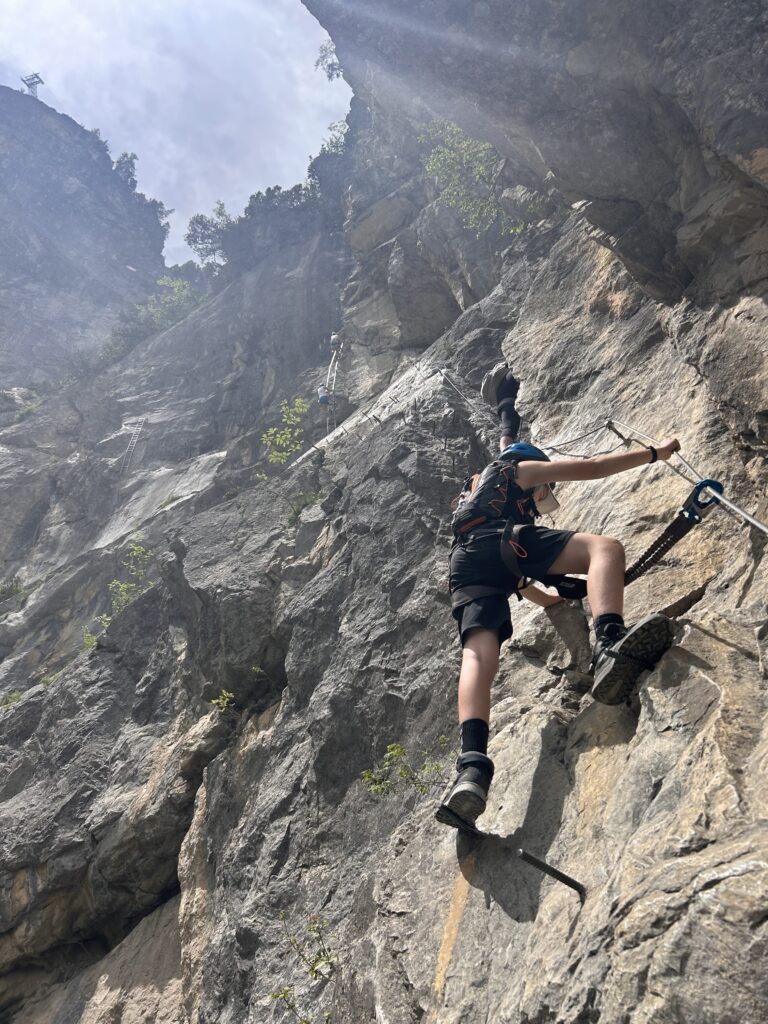 people on via ferrata on side of cliff