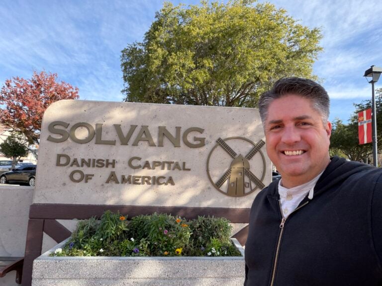 man standing in front of Solvang welcome sign